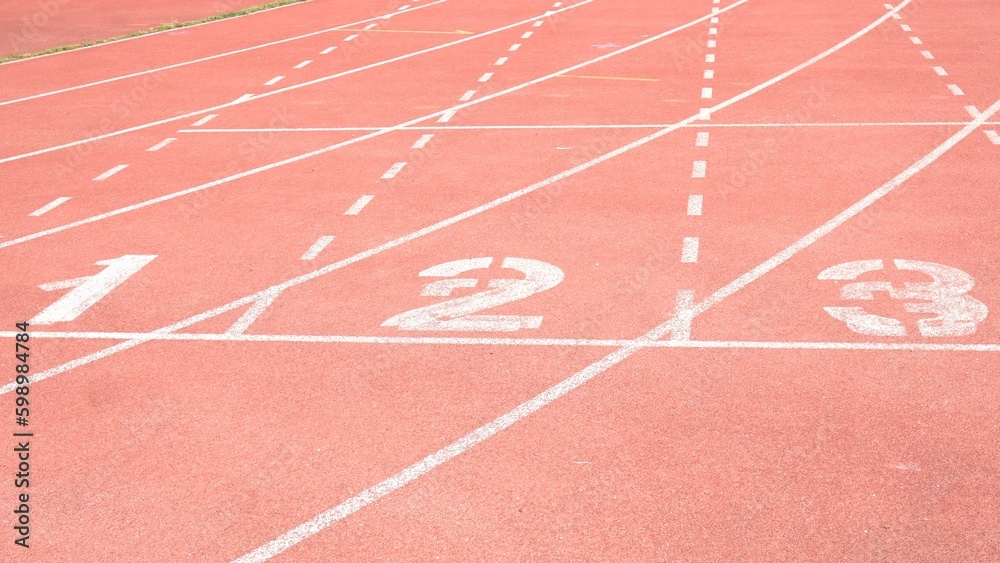 red running track start with starting numbers of running race between athletes in sport competition