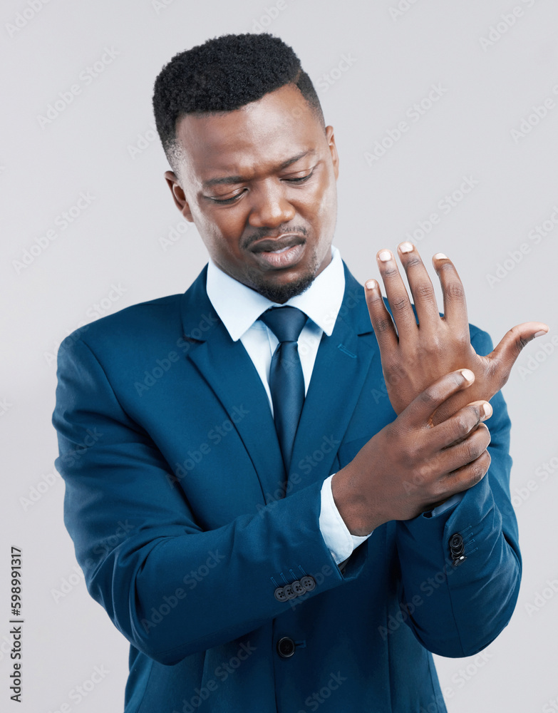 Could this be carpal tunnel syndrome. Studio shot of a young businessman experiencing wrist tension against a grey background.