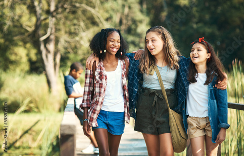 Making new friends and making lots of memories. a group of teenage girls walking and chatting in nature at summer camp. © N F/peopleimages.com