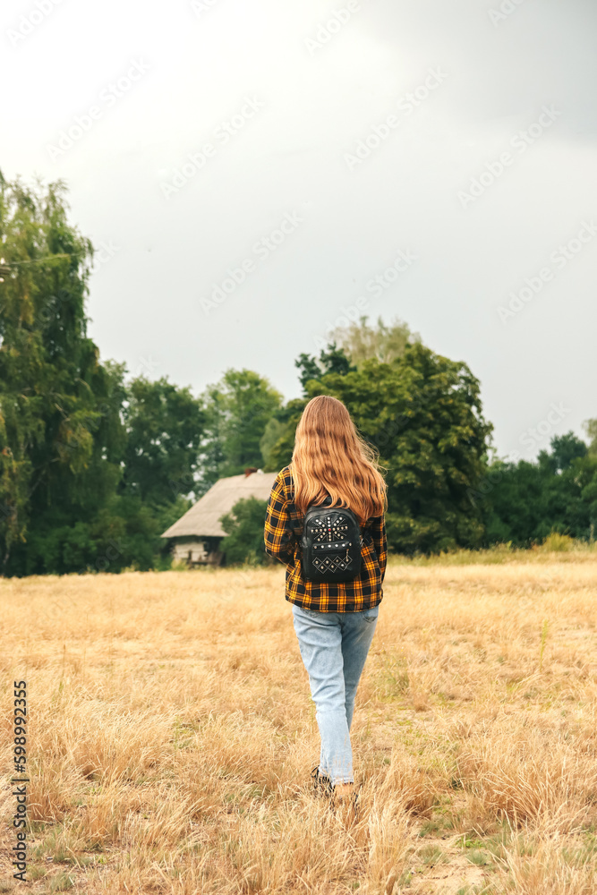 Backpack woman. Hipster girl with backpack in savanna desert. Traveler background. Tourist summer lifestyle. Blonde curly hair. Teenager style. Hiking. Walking nature. Vertical Backpack woman. Hipster girl with backpack in savanna desert. Traveler background. Tourist summer lifestyle. Blonde curly hair. Teenager style. Hiking. Walking nature. Vertical