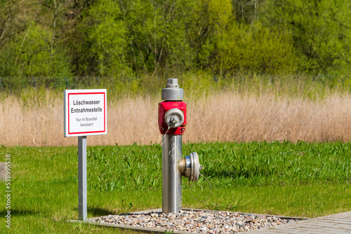 Symbolbild Brandschutz Hydrant auf einem Industriegelände mit Schild Löschwasser Entnahmestelle Nur im Bedarfsfall benutzen