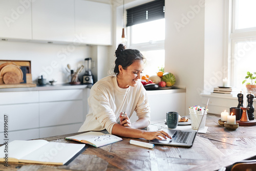 Woman working online at her kitchen table