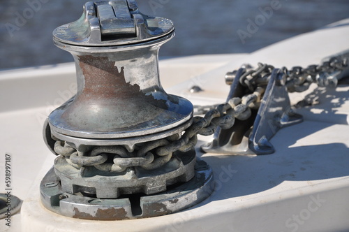 Photography Metallic rusty anchor windlass on a white boat at the sea