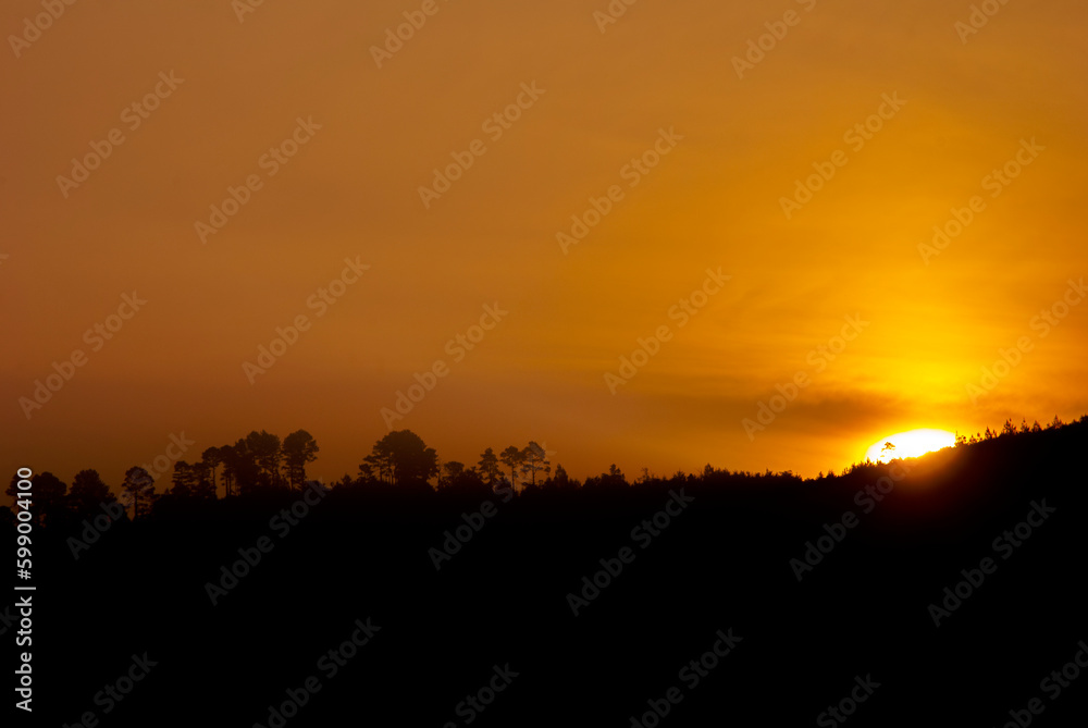 Sunrise projecting silhouette of mountains in rural and wooded area of central america, imposing presence of light in summer morning. Sunrise projecting silhouette of mountains in rural and wooded area of central america, imposing presence of light in summer morning.