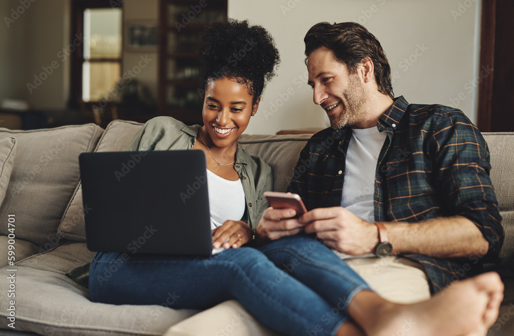 We just share a special connection between us. a happy young couple using a laptop and cellphone while relaxing on a couch home. We just share a special connection between us. a happy young couple using a laptop and cellphone while relaxing on a couch home.