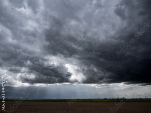 dramatic storm clouds over a farm field © jr-art
