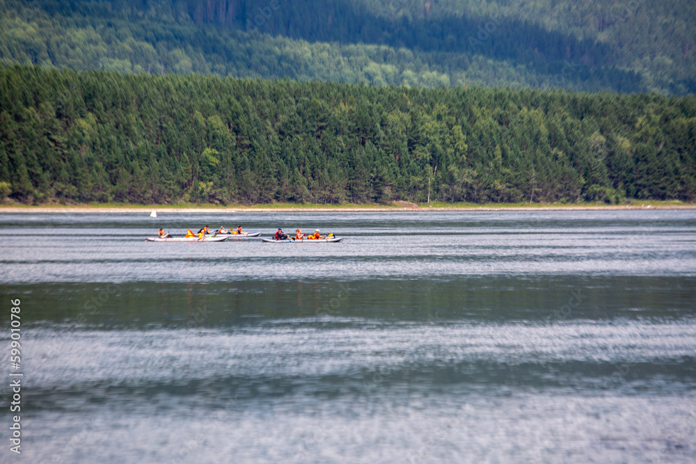 Obraz premium Tourists on boats float down the river in the wilderness in summer. Tourism, active recreation.