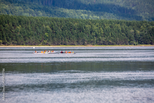 Tourists on boats float down the river in the wilderness in summer. Tourism, active recreation.