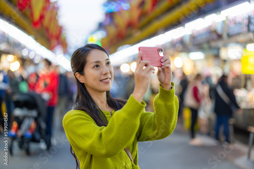 Woman use cellphone to take photo in Keelung street market of Taiwan © leungchopan