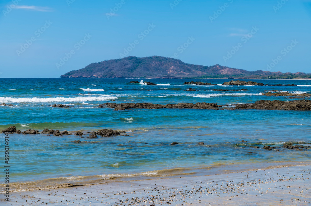 A view over rock outcrops out into the bay at Tamarindo in Costa Rica in the dry season