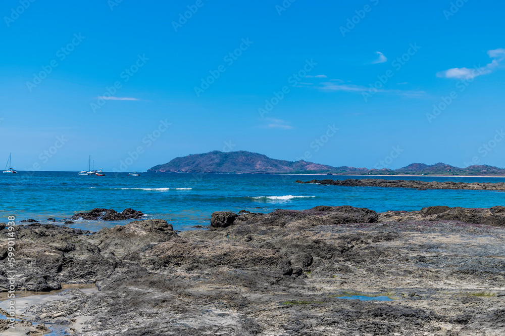 A view past the rocky beach out into the bay at Tamarindo in Costa Rica in the dry season