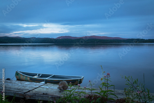 lake at the blue hour, fishing boat on the shore by the deck
