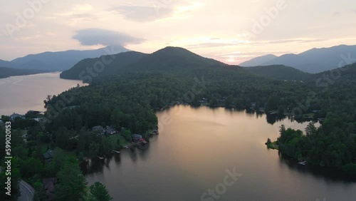 4K Drone Aerial Arc Orbit of Sunrise over Lake Placid with Mountains. Reflection of sunrise in lake