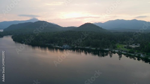4K Aerial Drone Arc Orbit of Sunrise over Lake Placid with Mountains. Reflections visible in lake