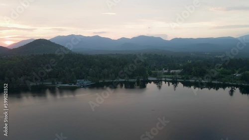 4K Aerial Drone Arc Orbit of Sunrise over Lake Placid with Mountains. Reflections in lake