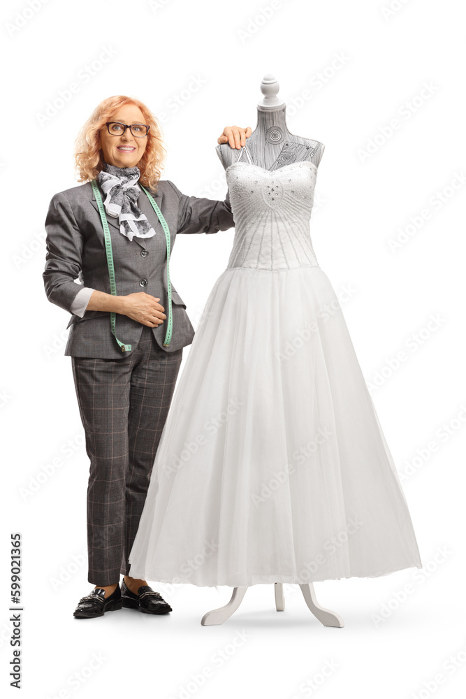 Seamstress posing with a bridal gown on a mannequin doll