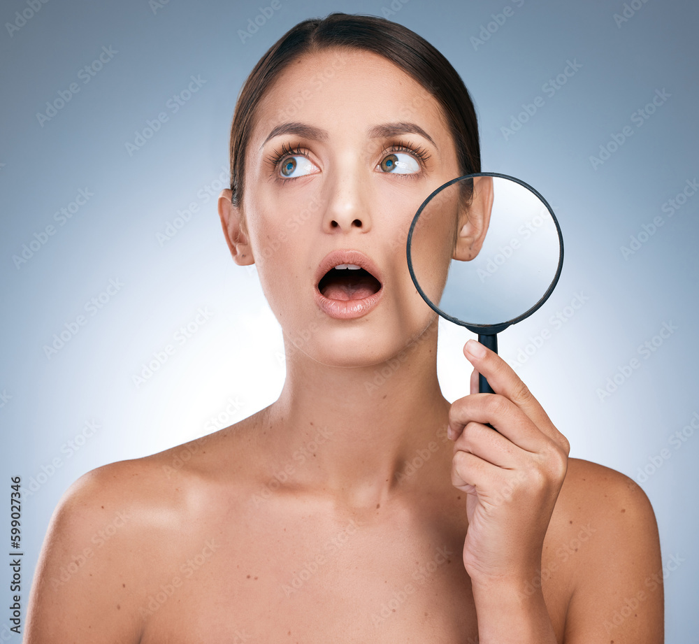 Seeing it all unfold but theyre just watching. a young woman using a magnifying glass to check her skin against a blue background. Seeing it all unfold but theyre just watching. a young woman using a magnifying glass to check her skin against a blue background.