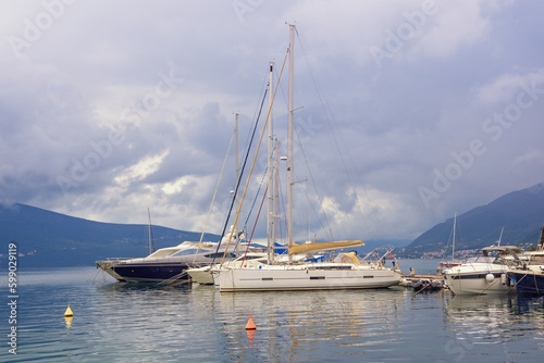 Sailboats on water  beautiful Mediterranean landscape. Montenegro  Adriatic Sea. View of Bay of Kotor near Tivat city on cloudy day