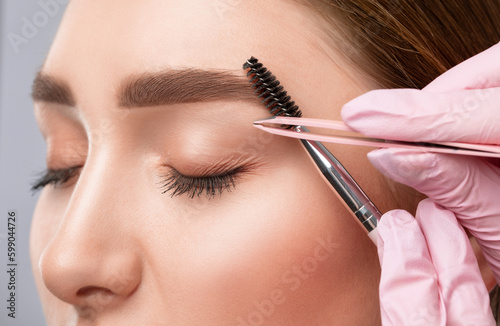 The make-up artist does Long-lasting styling of the eyebrows of the eyebrows and will color the eyebrows. Eyebrow lamination. Professional make-up and face care.