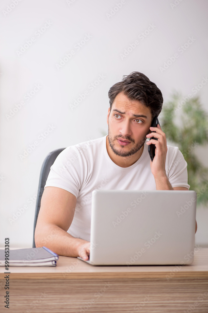 Young male employee working in the office Young male employee working in the office
