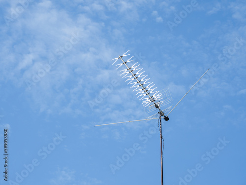 TV rooftop antenna on blue sky background. Industrial equipment used to receive internet signal, television connection and communication.