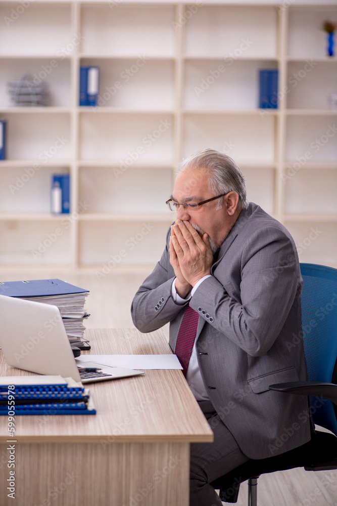 Fototapeta premium Old male employee working in the office