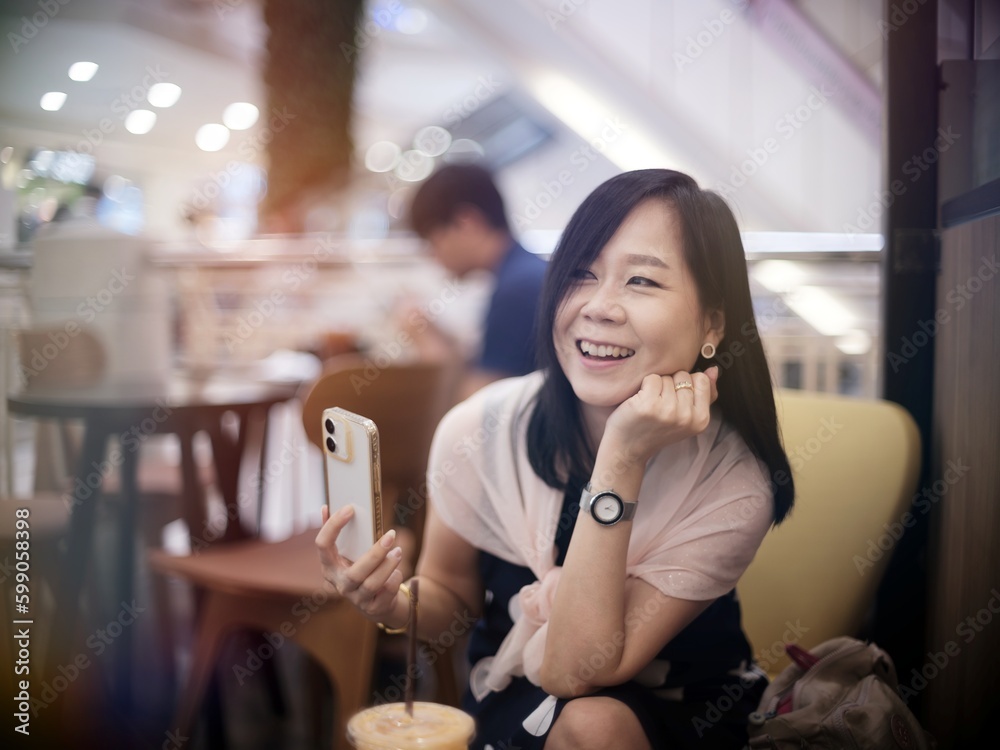 Urban modern lifestyle portrait of asian female stylish casual Asia woman sitting with coffee cup and smartphone connection in the cafe Urban modern lifestyle portrait of asian female stylish casual Asia woman sitting with coffee cup and smartphone connection in the cafe