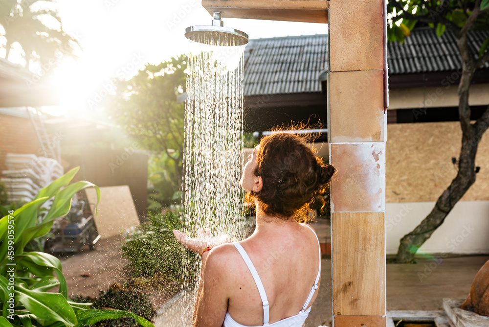 Wall Mural Woman taking an outdoor shower at a dream vacation resort.