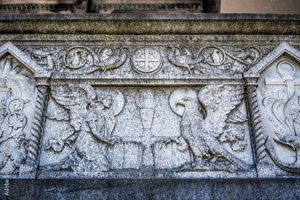 Bas-relief with angel and eagle on a grave in the Monumental Cemetery of Milan, Lombardy region, Italy, where many notable people are buried.