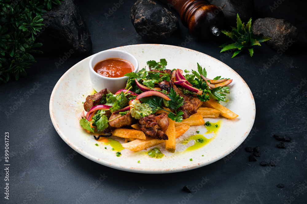 Fried pork fillet with French fries, onion, sauce and greens. Fried pork fillet with French fries, onion, sauce and greens.
