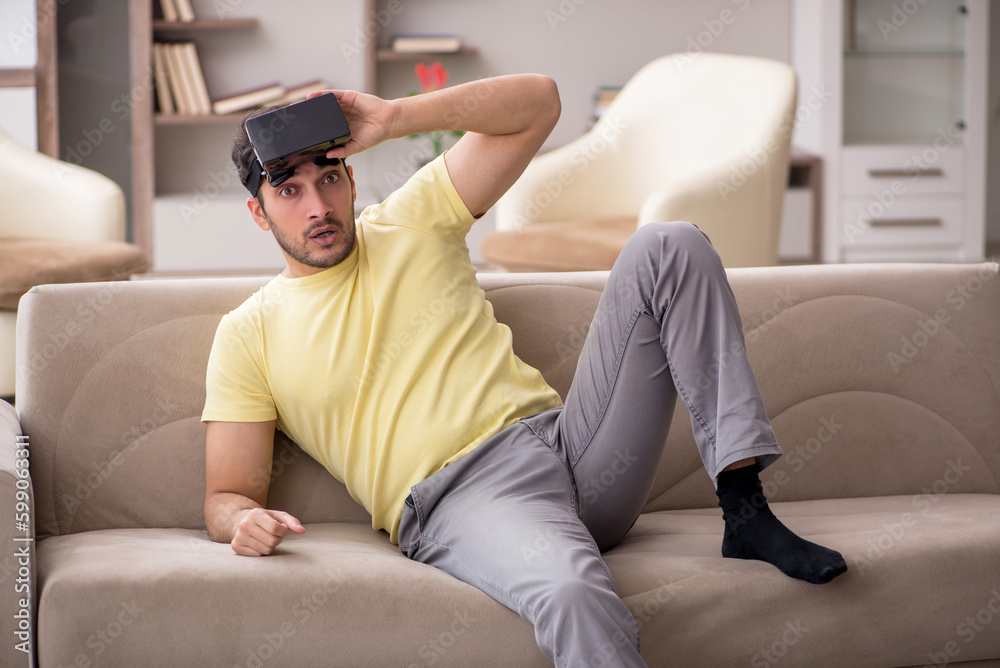 Young man enjoying virtual glasses at home Young man enjoying virtual glasses at home
