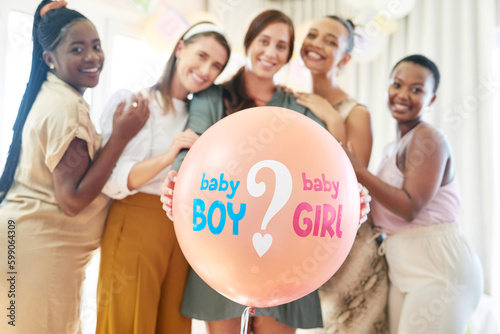 Party games are always fun. a group of women about to pop a balloon for a gender reveal during a baby shower.