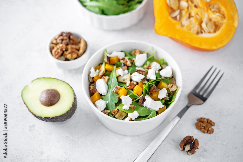 Roasted pumpkin avocado arugula goat cheese salad in a plate