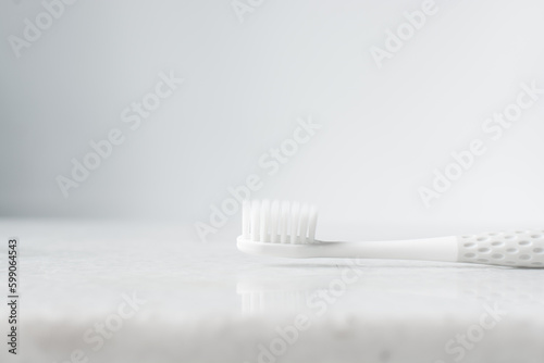 Grey toothbrush with white bristles on a white background  Grey toothbrush with copy space