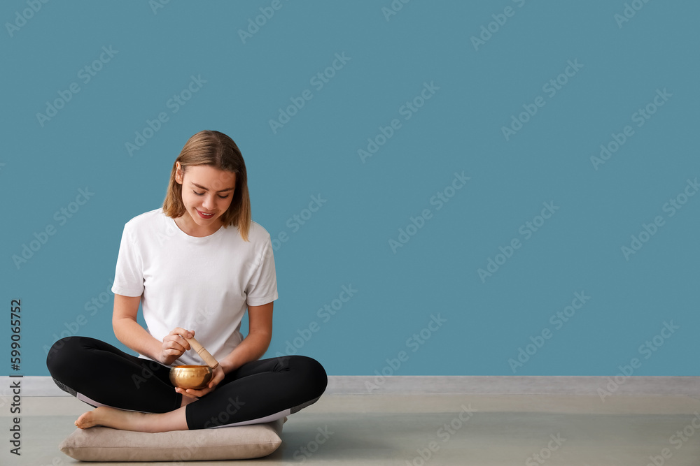 Fototapeta premium Young woman with Tibetan singing bowl at home