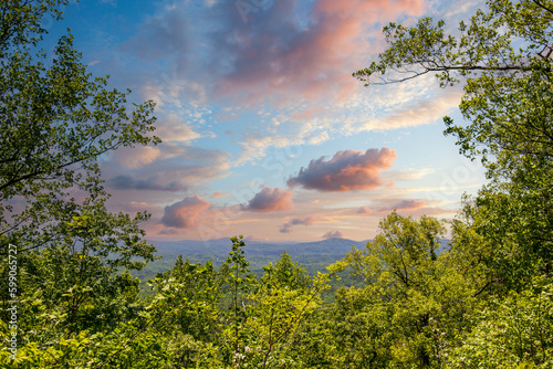 a gorgeous spring landscape with lush green trees and plants and mountains covered in lush green foliage with powerful clouds at sunset at Amicalola Falls State Park in Dawsonville Georgia USA photo