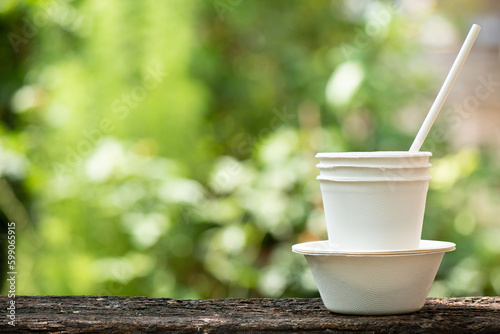Green packaging such as cups on nature background.
