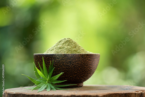 Marijuana branch green leaves and powder on nature background.