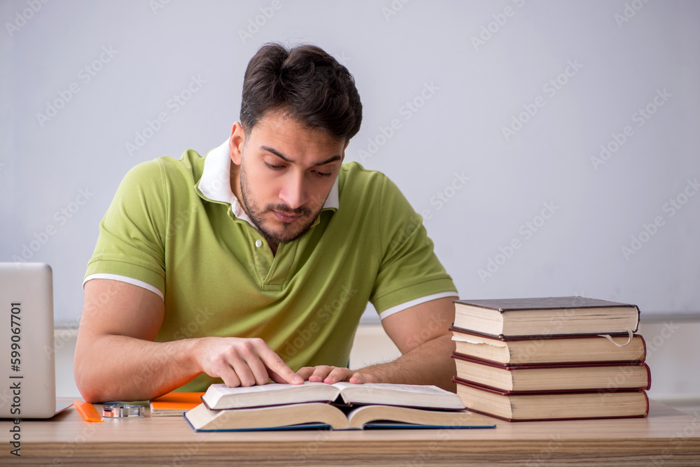 Young male student sitting in front of whiteboard Young male student sitting in front of whiteboard