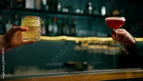 Close up of two people cheering cocktails in a bar or disco club drinks and cocktails concept
