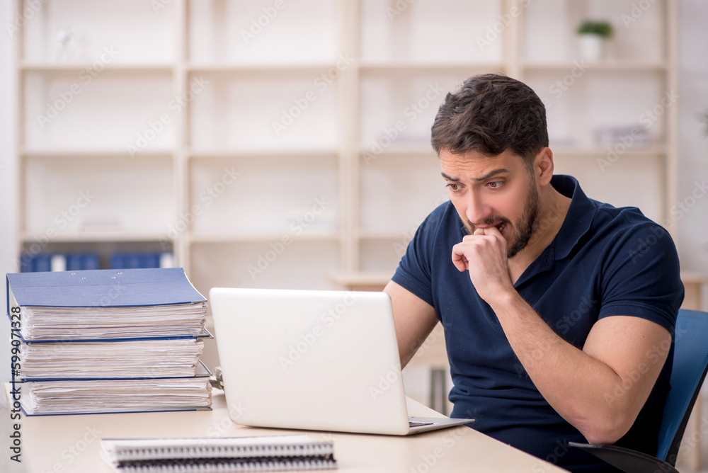 Young male employee sitting at workplace Young male employee sitting at workplace
