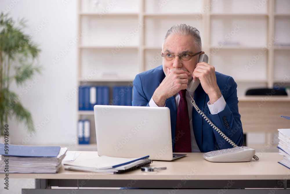 Old male employee and too much work at workplace Old male employee and too much work at workplace