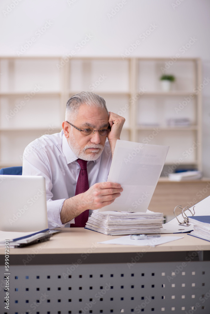 Old male employee and too much work at workplace Old male employee and too much work at workplace
