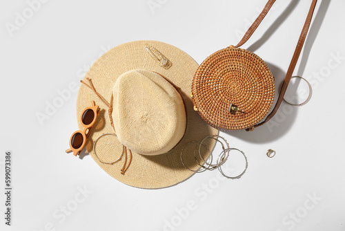 Fotografie Jewelry with sunglasses, bag and summer hat on white background