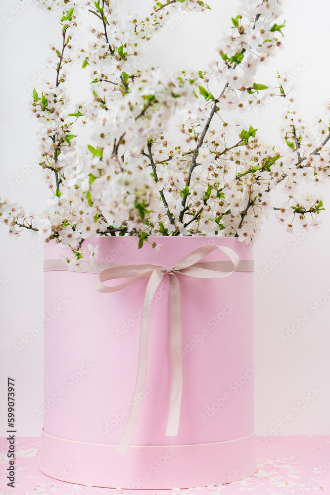 Fototapeta premium tree branches with blooming spring flowers in a pink gift box