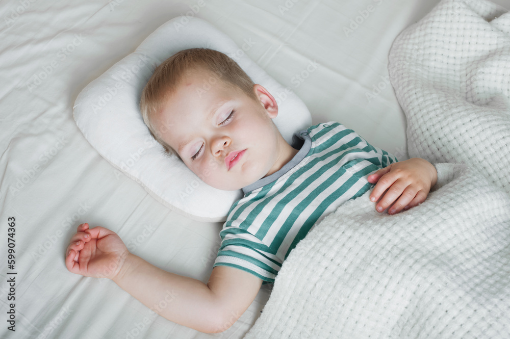 Naklejka premium Toddler boy sleeping close-up on bed. Health care concept