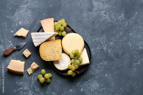 фотографія Different types of cheese with grapes on blue background