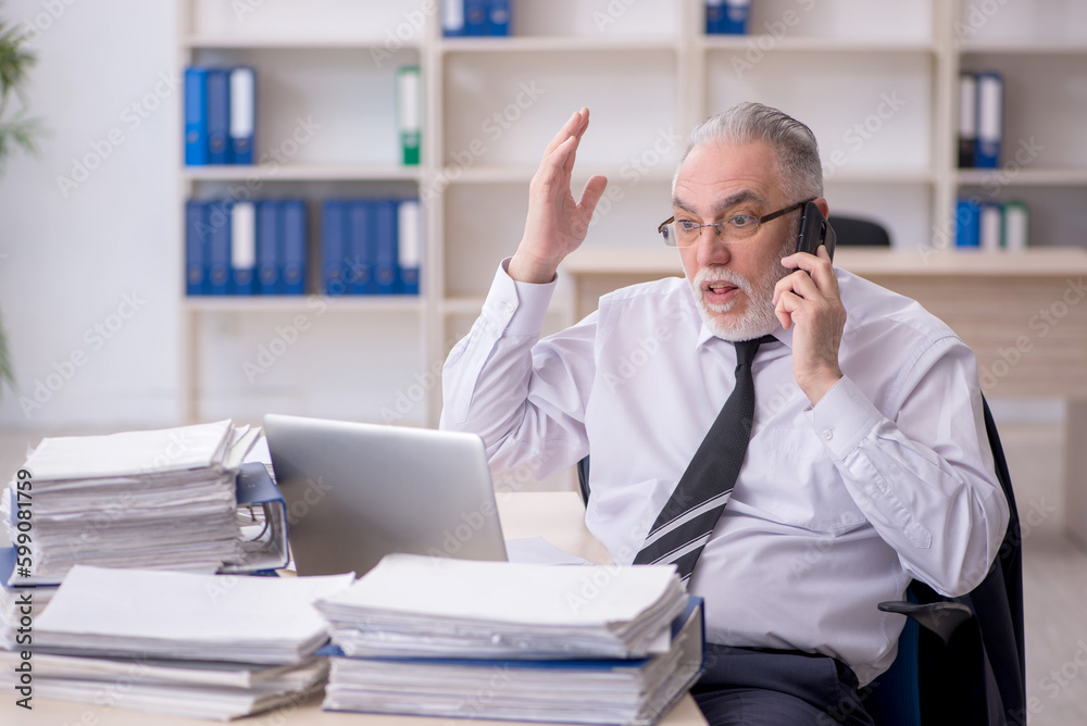 Old male employee and too much work at workplace Old male employee and too much work at workplace