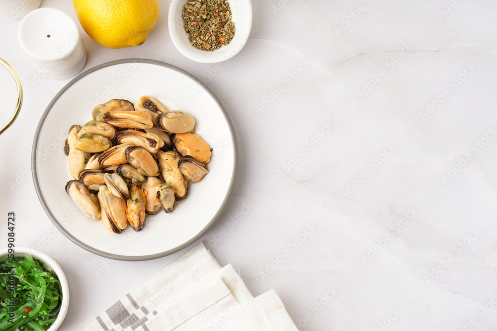 Plate with pickled mussels and bowl of seaweed salad on white background Plate with pickled mussels and bowl of seaweed salad on white background