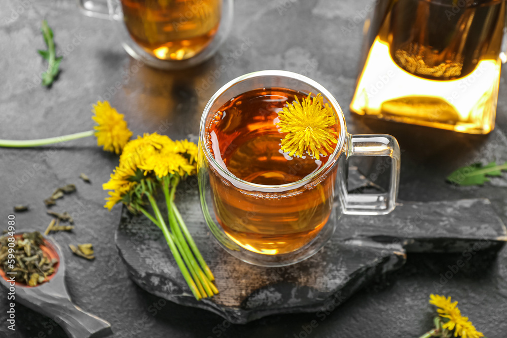 Board with glass cups of healthy dandelion tea on black background Board with glass cups of healthy dandelion tea on black background